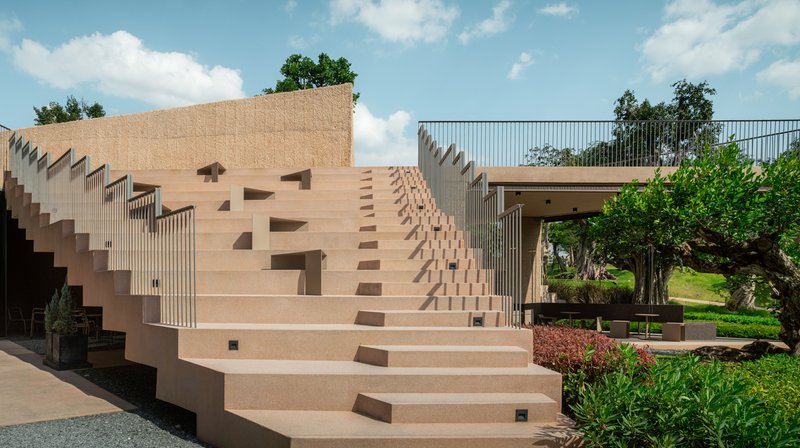 Wide concrete staircase with recessed lighting stepping up through the courtyard on a sunny afternoon