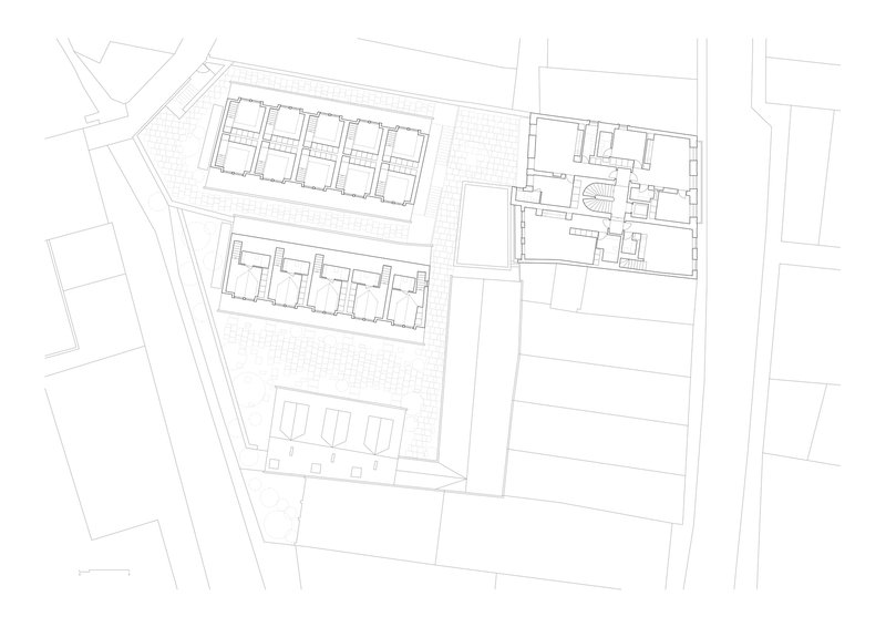 Upper floor plan drawing showing row housing units with pitched roof outlines and adjacent building wing