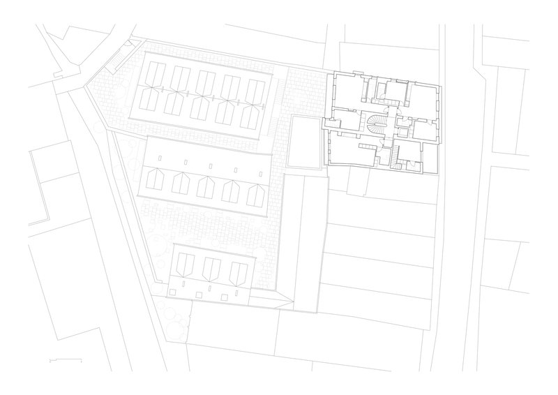 Floor plan drawing depicting rows of gabled housing units on angled site with neighboring structure