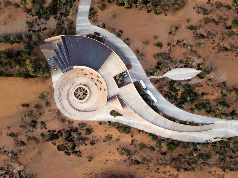 Aerial view of the spiral amphitheater and curving concrete access road through arid scrubland