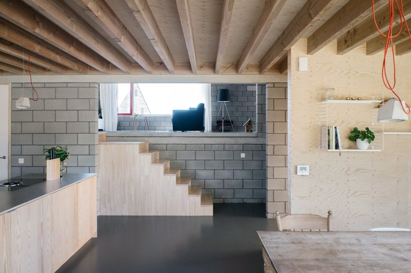 Interior view under exposed timber joists showing split-level arrangement and concrete block partition wall