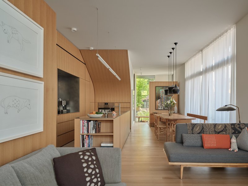 Open plan living space with bamboo cabinetry and sheer curtains filtering afternoon light