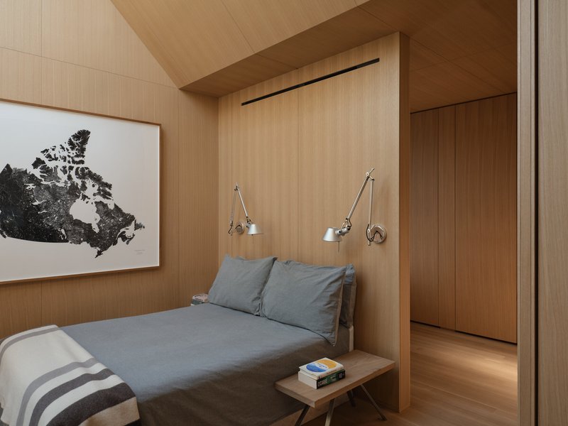 View toward bedroom doorway showing articulated swing-arm reading lamps flanking the bed