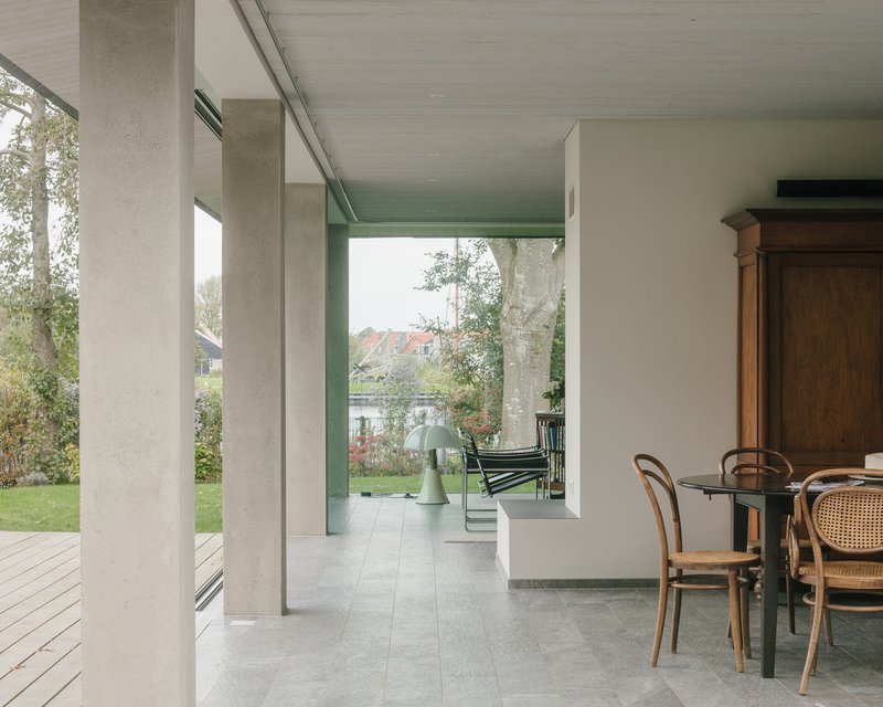 Covered porch looking through concrete columns toward the garden and water beyond