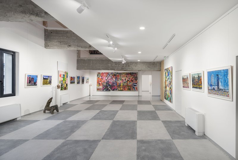 Gallery hall with checkerboard flooring and exposed concrete beams supporting the white ceiling