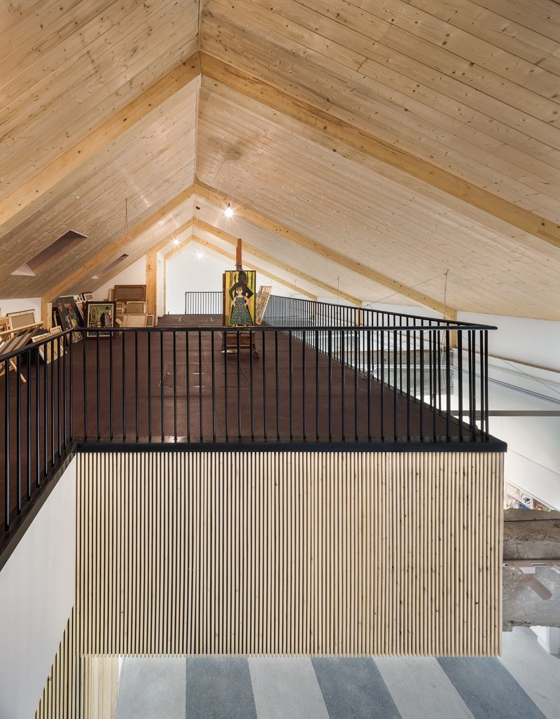 Upper level mezzanine with timber slat balustrade beneath a gabled timber ceiling with exposed beams