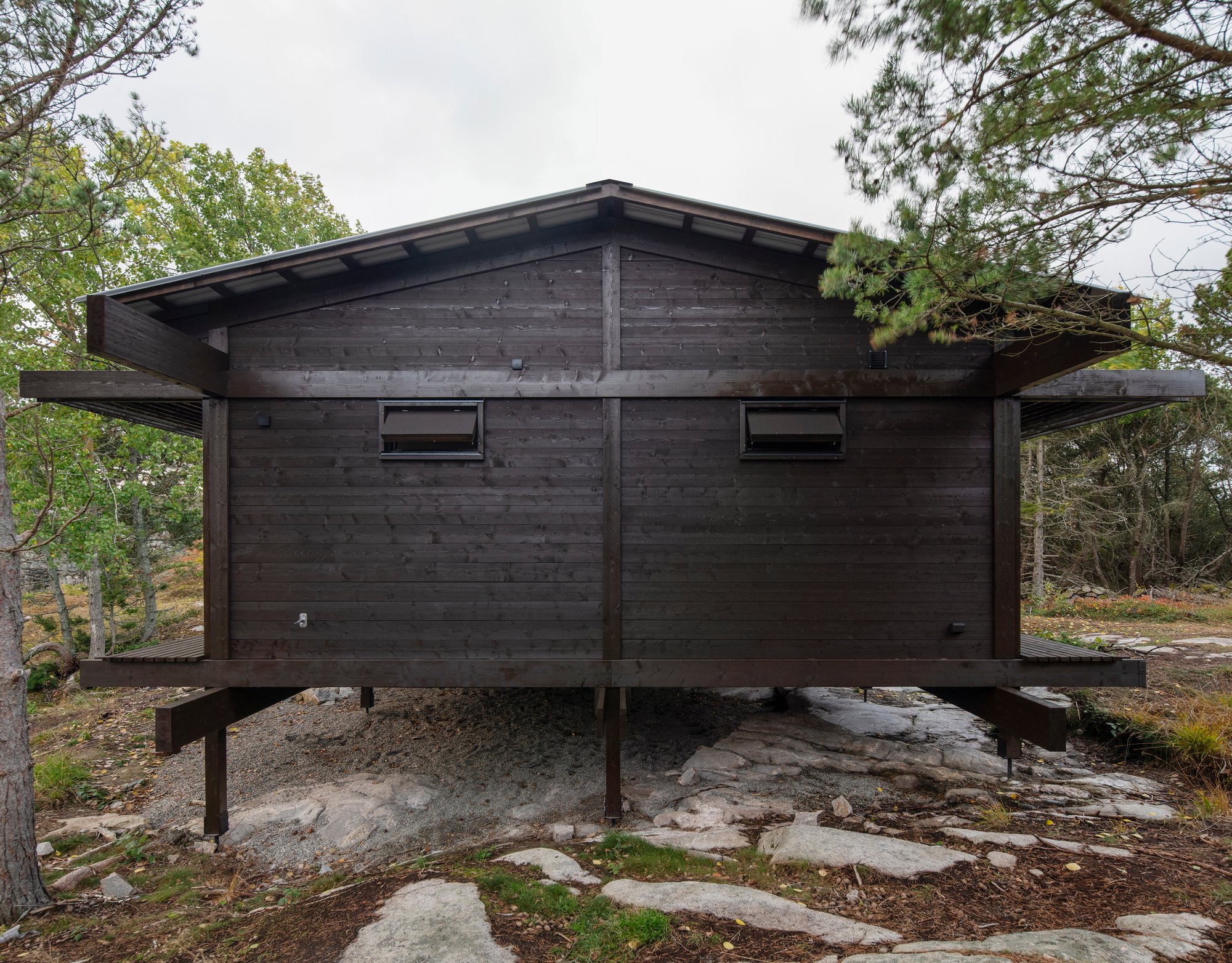 HelgessonGonzaga Raises a Tar-Coated Weekend Pavilion Above the Rocks of a Swedish Nature Reserve