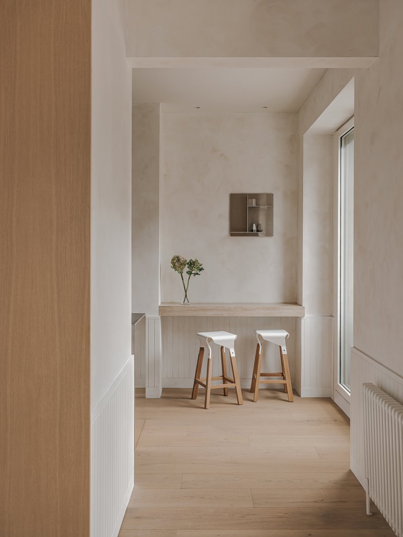 Kitchen counter with fluted panel base, two timber stools and dried flowers in a vase