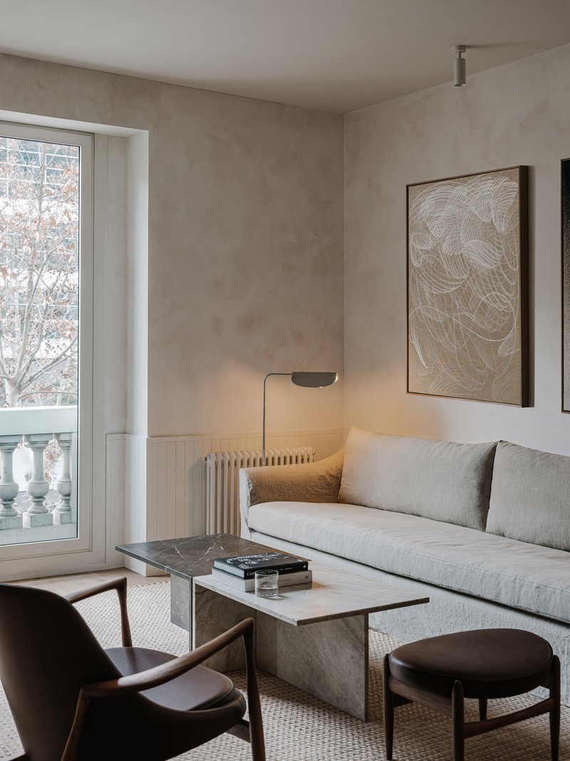 Sitting area with French doors opening to balcony overlooking bare winter trees outside