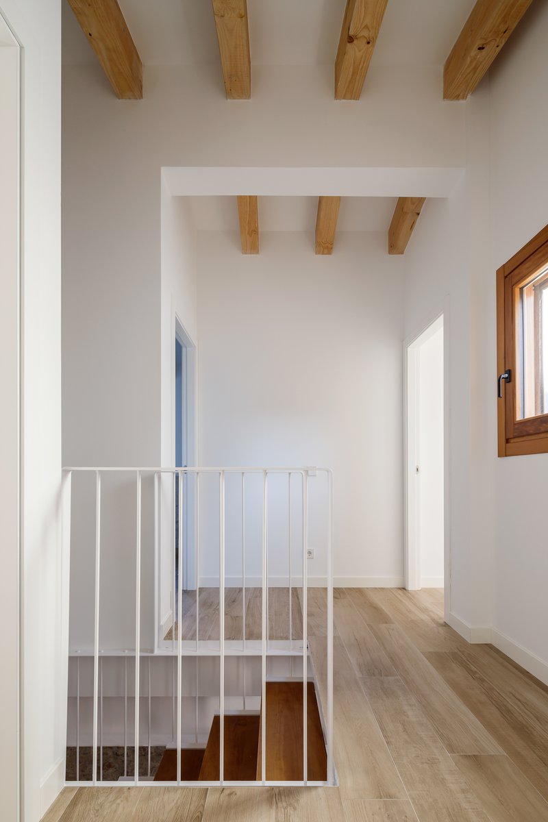 Upper hallway landing with white metal balustrade overlooking the stairwell below
