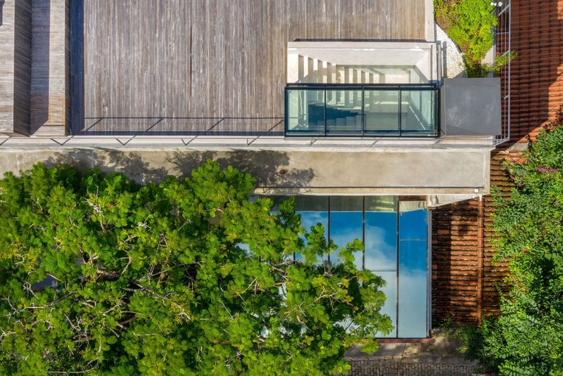 Aerial view of rooftop terrace with glass pavilion and weathered concrete deck