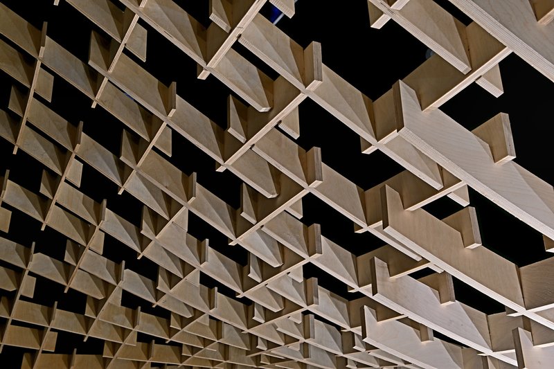 Detail view of the woven timber lattice forming a parametric grid against darkness