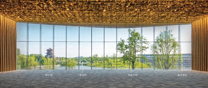 Interior view through floor-to-ceiling glass overlooking trees and a distant pagoda