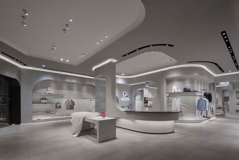 Wide view of the retail interior showing curved ceiling planes with integrated lighting and display alcoves