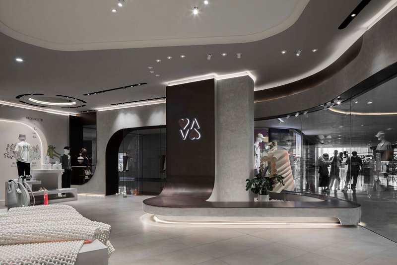Central circulation space showing the curved reception desk with backlit signage and shoppers in the background
