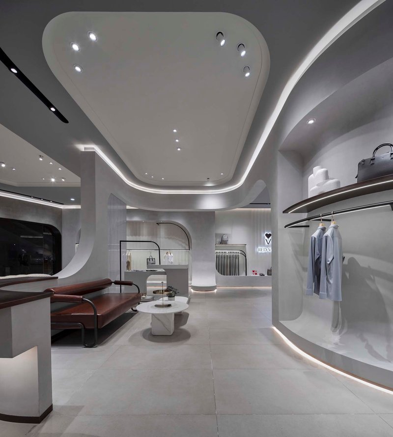 Seating area with curved ceiling soffit and illuminated display niches along perimeter wall