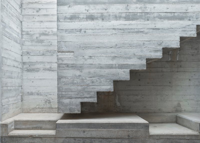 Intersecting concrete stair volumes with board-formed texture and varied tread depths at multiple levels