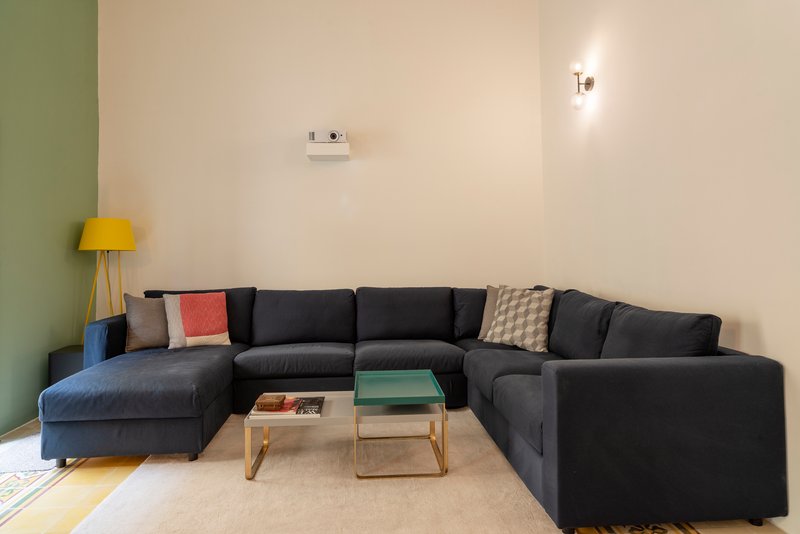 Living room with dark sectional sofa against olive green and cream walls