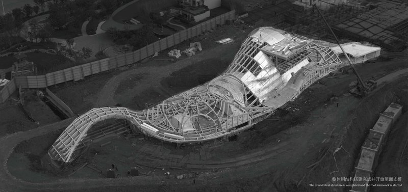 Aerial view of the undulating structural framework with exposed ribs during construction