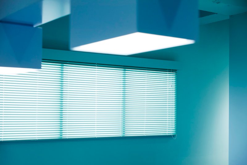 Interior corner with horizontal blinds and recessed skylight casting bright daylight into the room