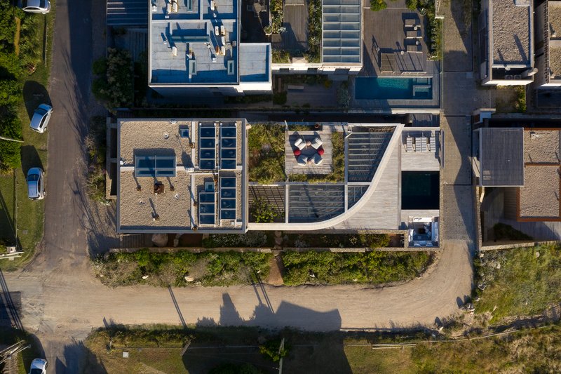 Aerial view showing the stepped roof terraces, courtyard plantings, and diagonal site shadows