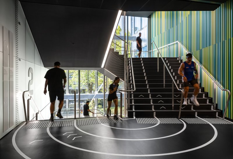 Entry foyer with central staircase and concentric circle floor pattern as visitors ascend and descend