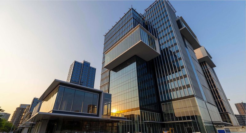 Cantilevered volumes with vertical metal fins and glass curtain wall at twilight