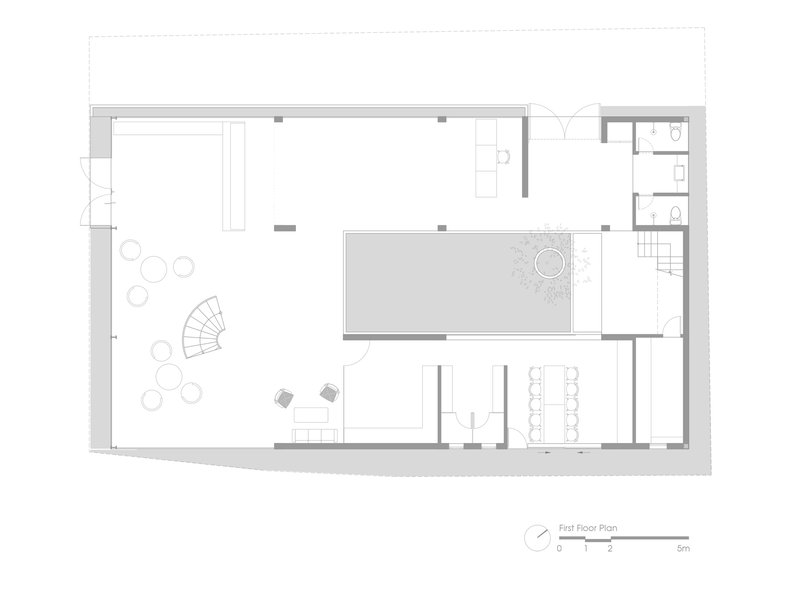 First floor plan drawing showing open spaces with a central courtyard and spiral stair
