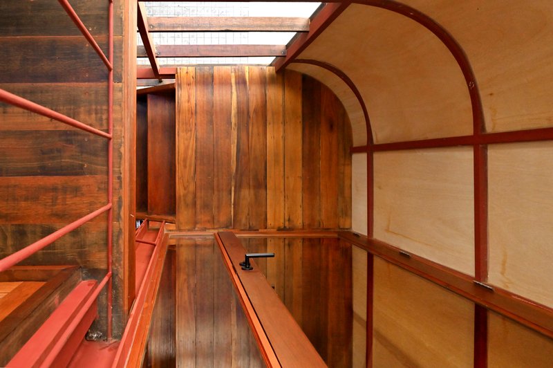 Interior stair landing with timber wall cladding and arched steel-framed translucent panels