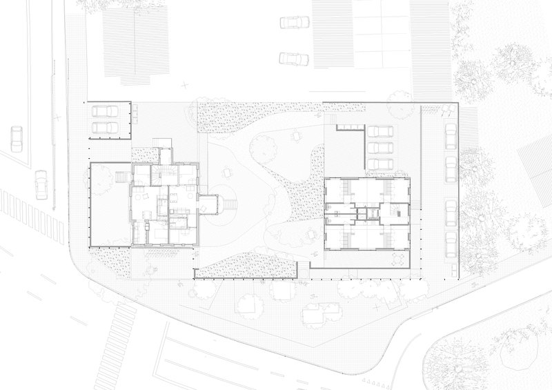 Site plan drawing showing two rectangular buildings flanking a courtyard with landscaping and parking areas