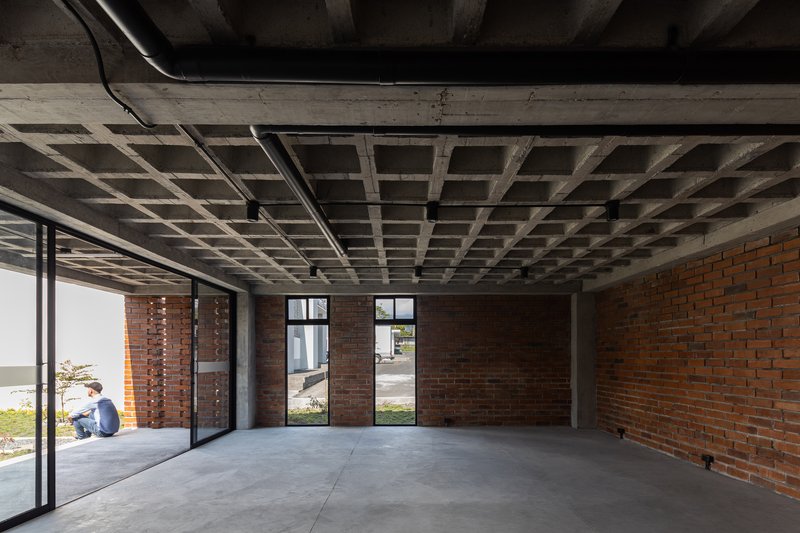 Interior space with exposed concrete ceiling joists, red brick walls and polished concrete floor