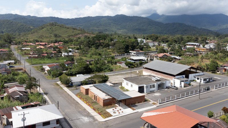 Drone view of the compound nestled in a residential neighborhood with forested mountains in the background