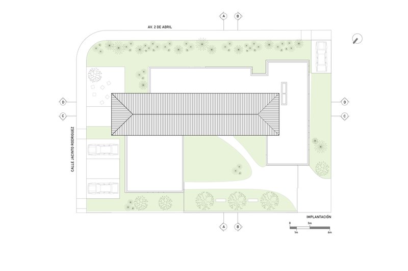 Site plan drawing with roof outline, landscaped areas, and tree symbols along the perimeter pathways