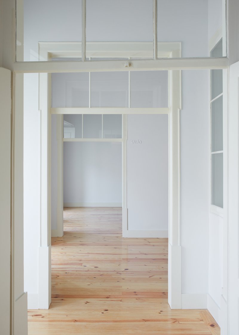 View through a timber-framed doorway with transom windows opening to adjacent rooms