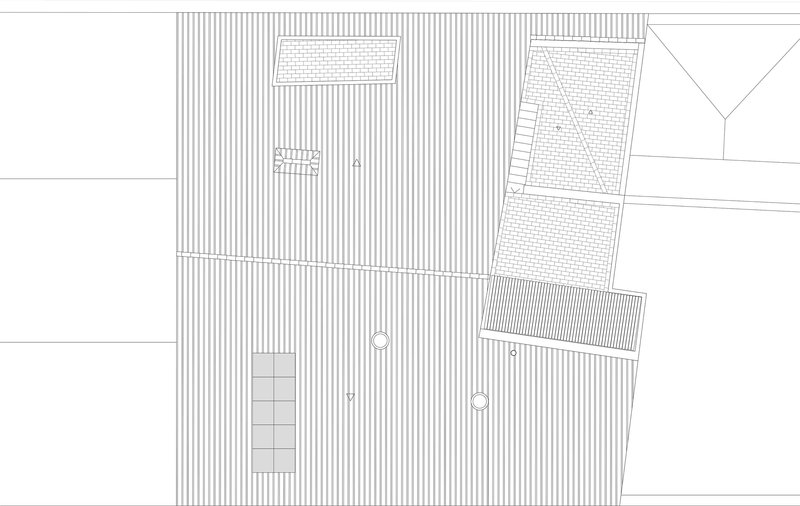 Site plan drawing showing the building footprint with striped paving and adjacent structures