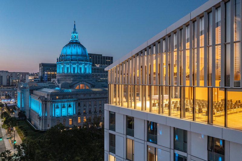 Upper-level glass-enclosed performance space overlooking the illuminated dome at twilight