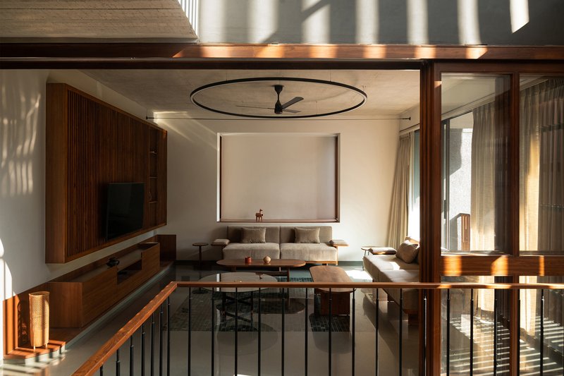 Upper living space with a circular ceiling fan ring and afternoon light filtering through timber screens