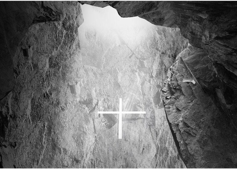 A glowing glass cross illuminates the rock-hewn chapel interior.