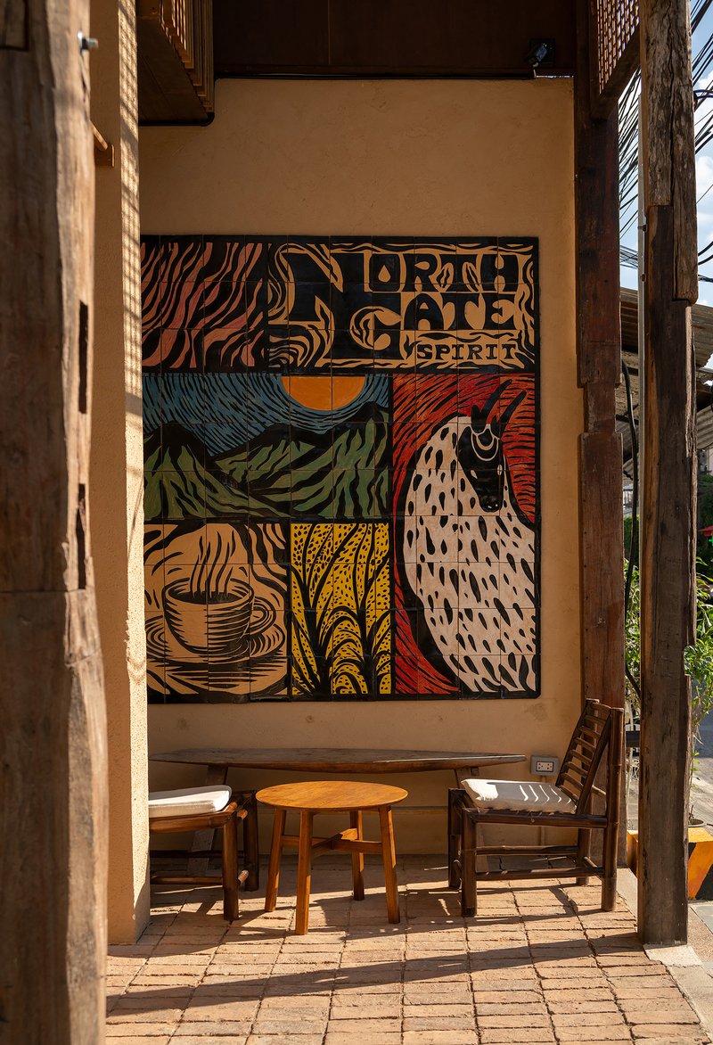 Interior courtyard seating area with mural and timber frame in morning sunlight