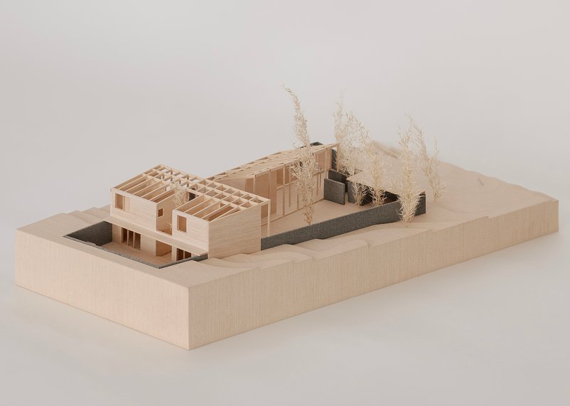 Physical model showing exposed timber framing and courtyard with miniature vegetation elements