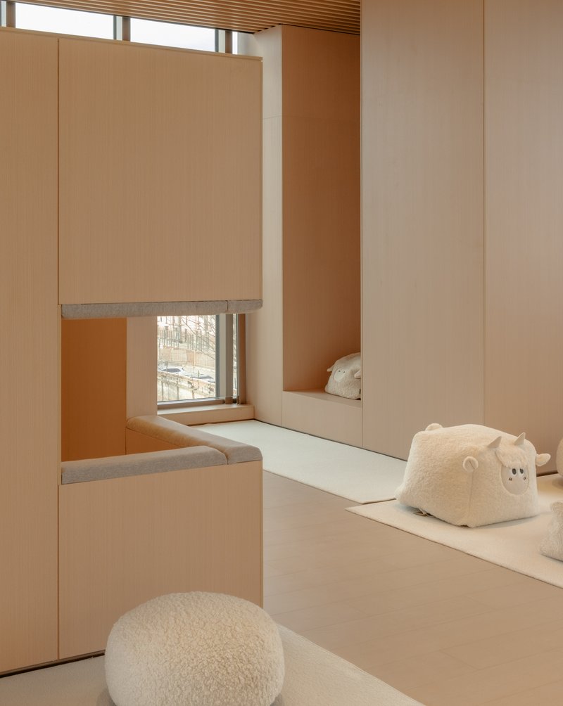 Corner nook with window seat, mirrored wall panels, and fleece cushions in afternoon light