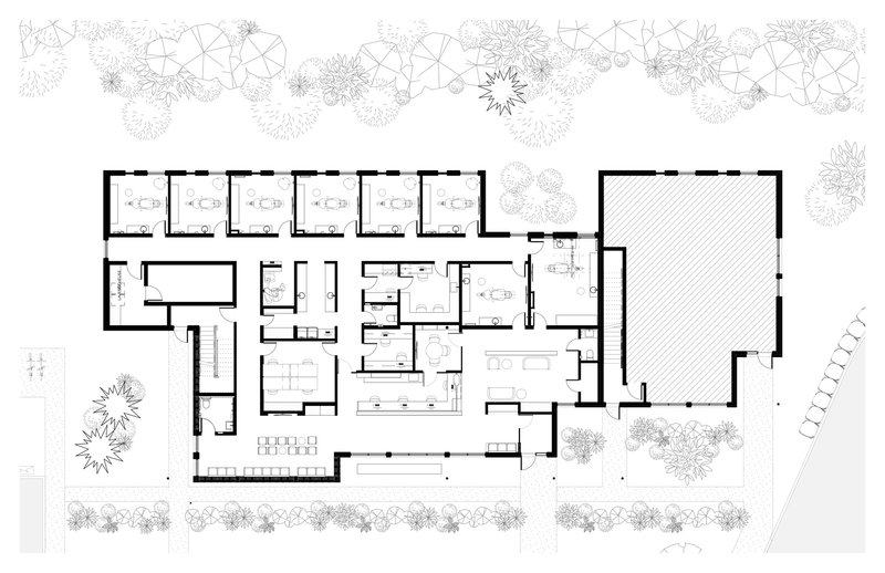 Floor plan drawing showing an L-shaped layout with covered terrace and surrounding landscape of trees