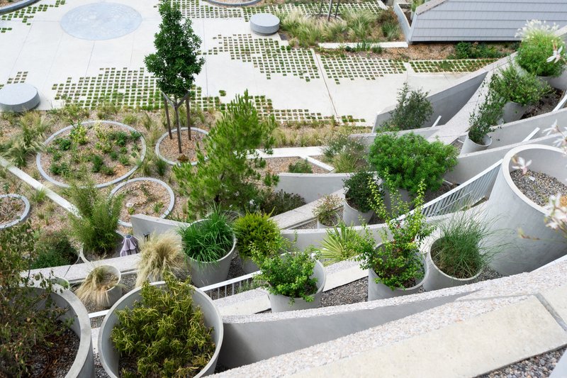 Aerial view of the curving white planter beds and permeable paving grid at ground level