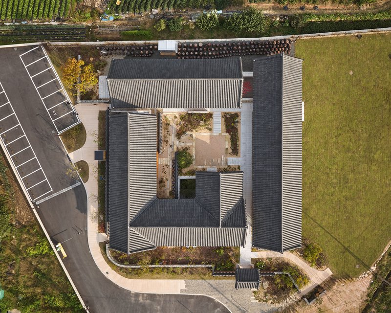Aerial view of the courtyard complex with tile roofs arranged around a central planted garden