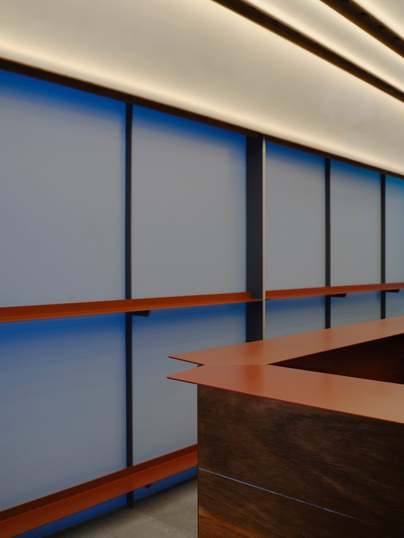 Angular copper countertop detail against the panel wall with backlit ceiling above