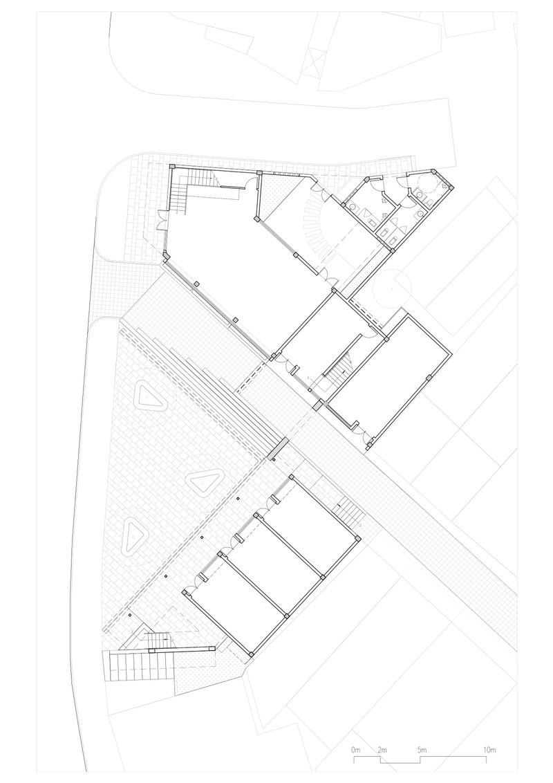 Ground floor plan drawing showing an angular building layout with interconnected rooms and exterior terraces