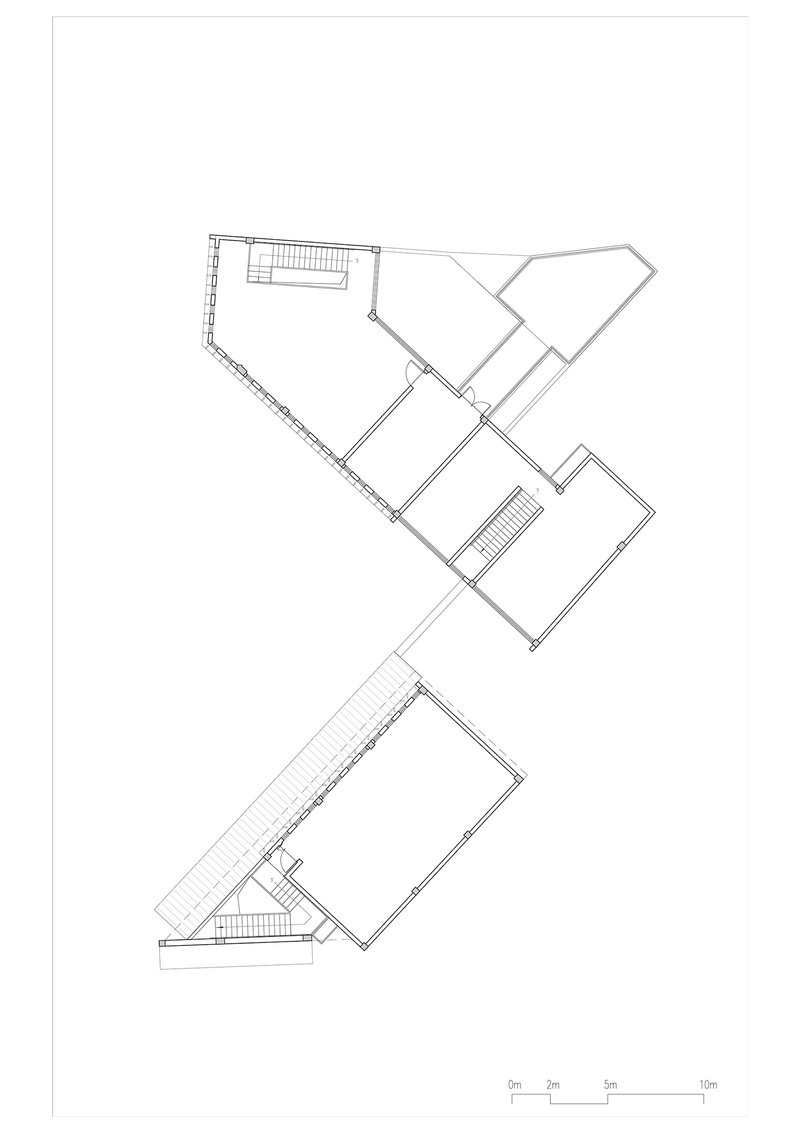 Upper floor plan drawing showing a fragmented building with angled wings and two staircases