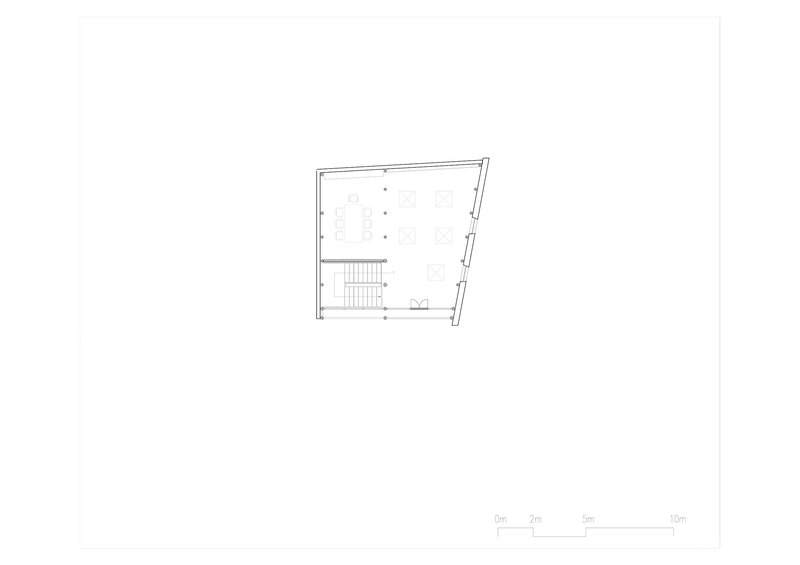 Floor plan drawing showing a trapezoidal volume with central staircase and distributed workspaces