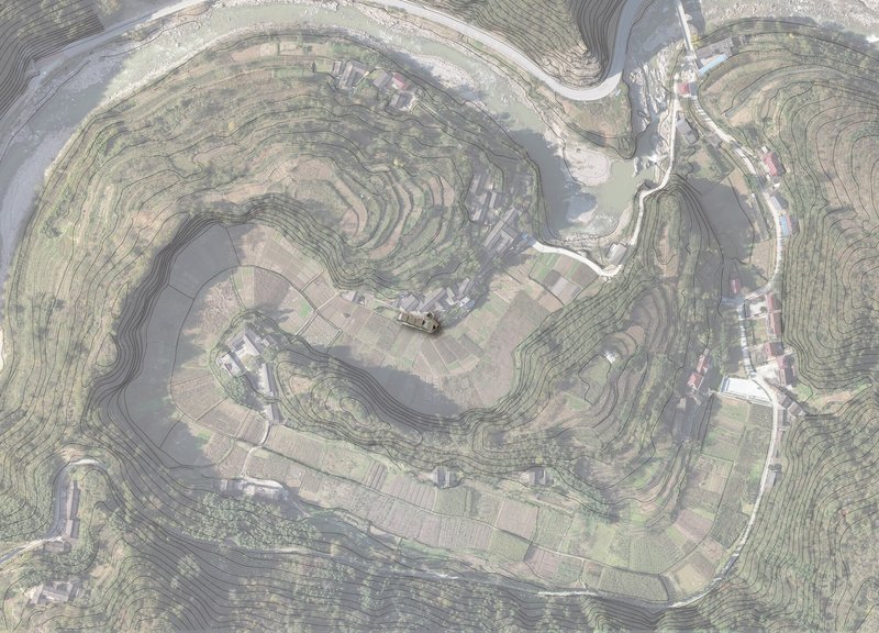 Overhead view of contoured farmland and scattered buildings following the topography of a hillside