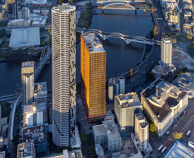 Drone view of the cylindrical and rectangular towers rising above the river and surrounding urban blocks